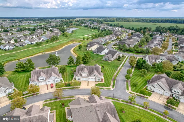 an aerial view of ocean and residential houses with outdoor space and seating