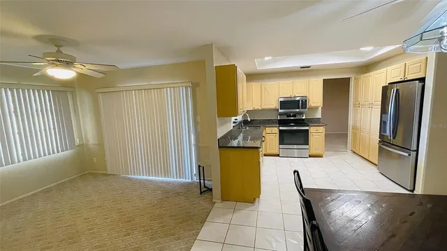 a kitchen with stainless steel appliances granite countertop a refrigerator a stove and a sink