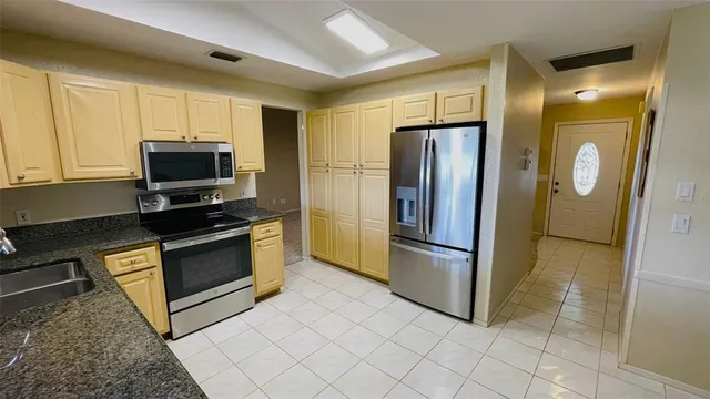 a kitchen with stainless steel appliances granite countertop a refrigerator and a stove top oven