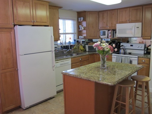 36 Edwardel Road Needham, MA 02492 - Photo 7 of 18 a kitchen with kitchen island granite countertop wooden cabinets a refrigerator a sink a stove and a refrigerator