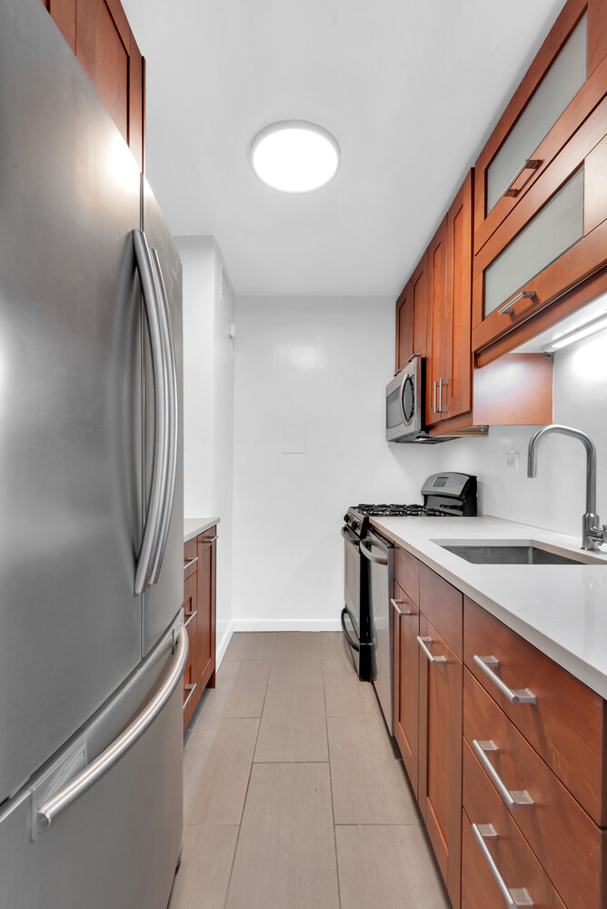 185 West End Avenue, Unit 16K Manhattan, NY 10023 - Photo 4 of 7 a kitchen with stainless steel appliances granite countertop a refrigerator and a sink