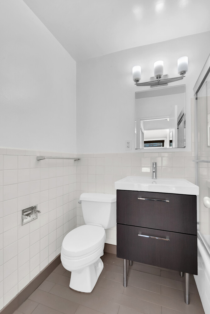185 West End Avenue, Unit 16K Manhattan, NY 10023 - Photo 5 of 7 a bathroom with a toilet a sink and mirror