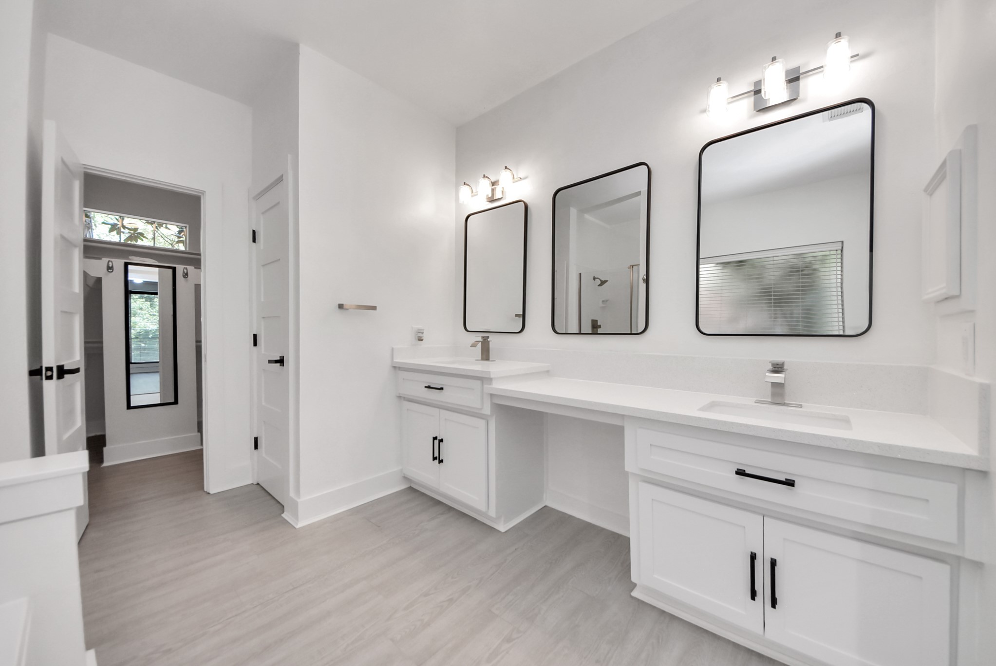 7522 Tumbling Road Humble, TX 77346 - Photo 25 of 48 Spacious and modern bathroom featuring dual vanities with sleek black-framed mirrors, elegant light fixtures, and ample natural light.