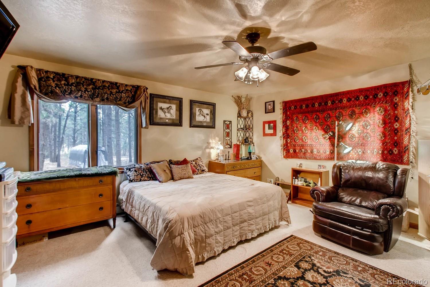 8060 Cyprus Road Colorado Springs, CO 80908 - Photo 13 of 28 a bedroom with a bed a couch and dresser