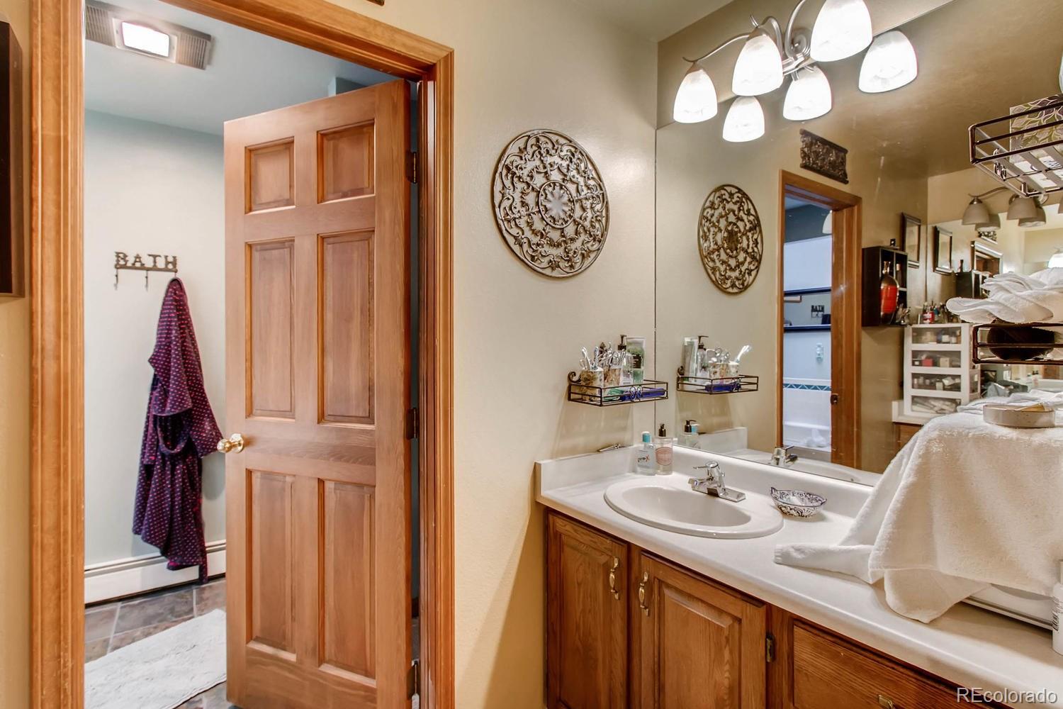 8060 Cyprus Road Colorado Springs, CO 80908 - Photo 15 of 28 a bathroom with a sink vanity and a mirror