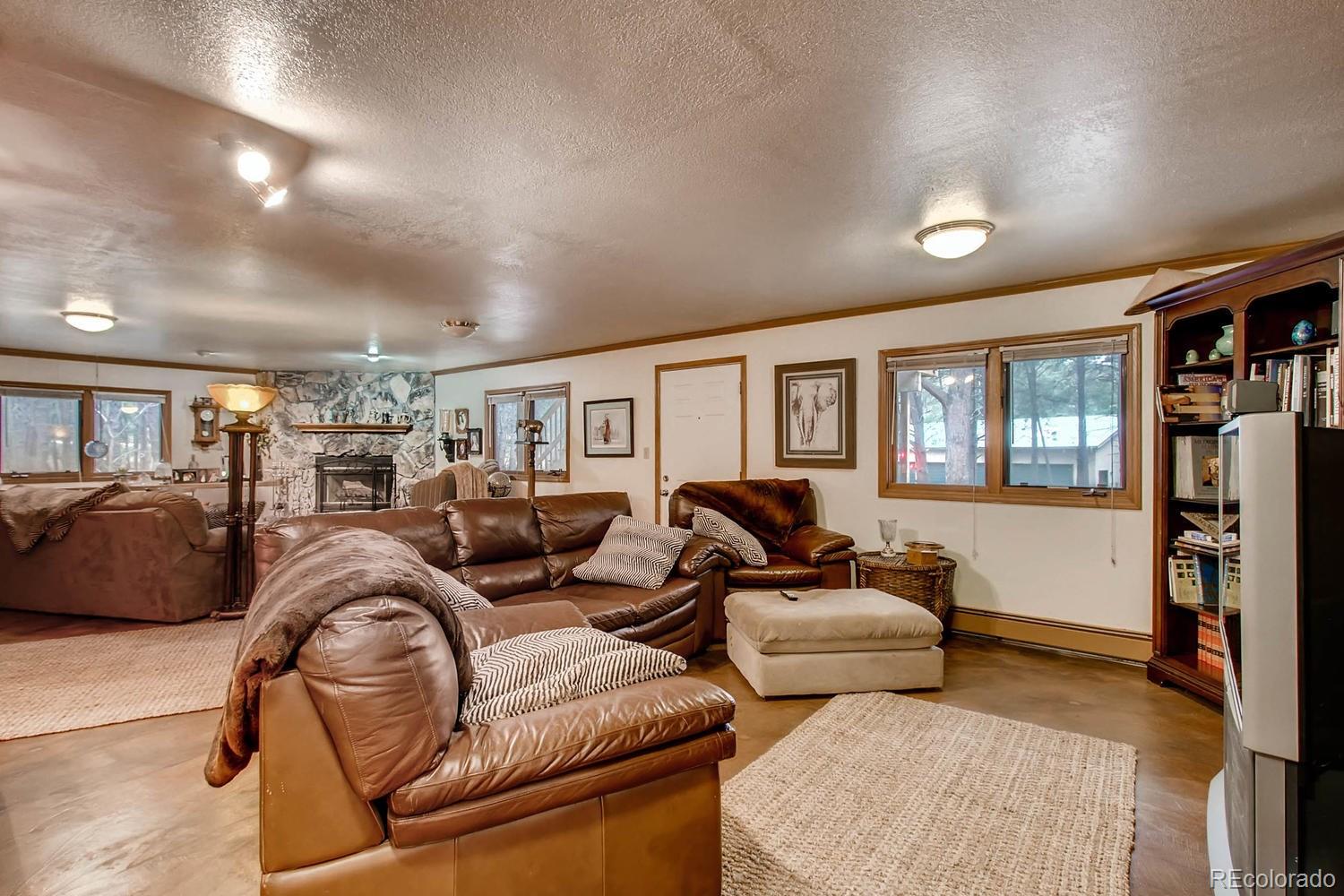 8060 Cyprus Road Colorado Springs, CO 80908 - Photo 19 of 28 a living room with furniture two window and a flat screen tv