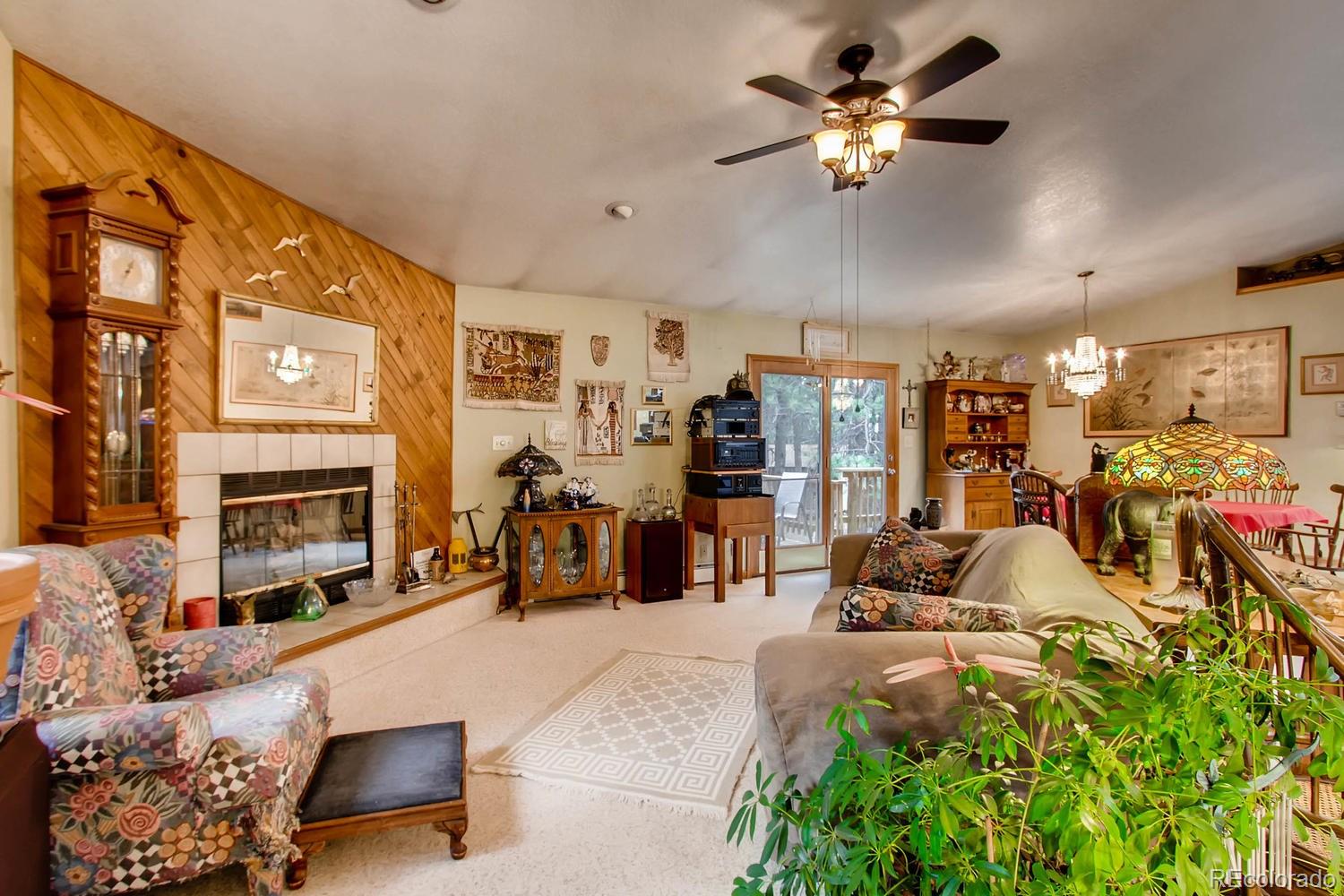 8060 Cyprus Road Colorado Springs, CO 80908 - Photo 5 of 28 a living room with furniture gym equipment and a chandelier
