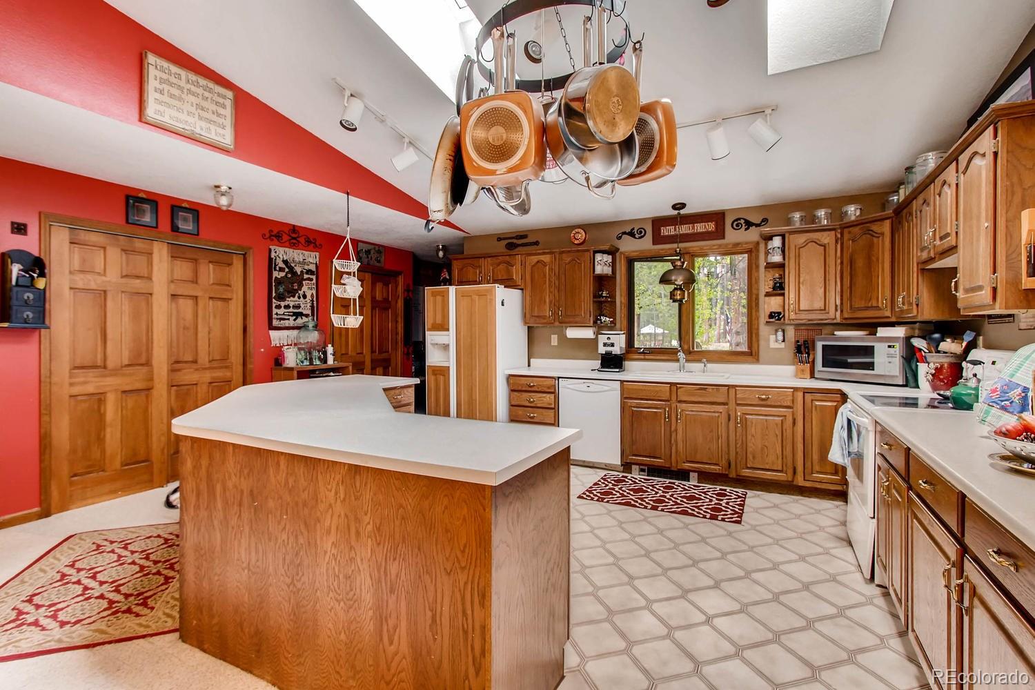 8060 Cyprus Road Colorado Springs, CO 80908 - Photo 8 of 28 a kitchen with stainless steel appliances kitchen island granite countertop a sink and cabinets