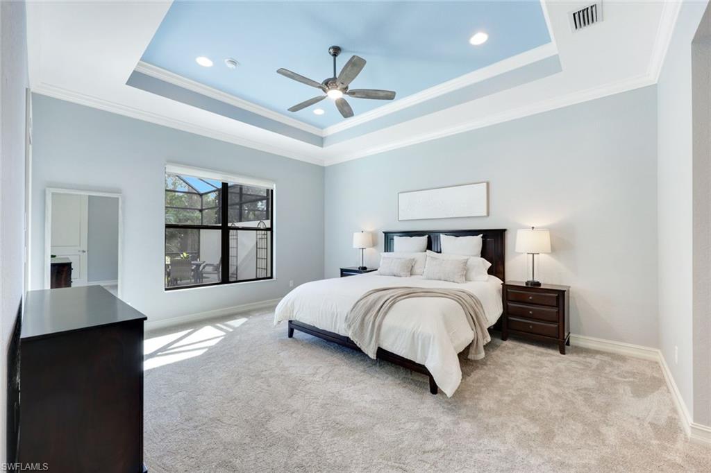 6592 Roma Way Naples, FL 34113 - Photo 14 of 41 Bedroom with a tray ceiling, crown molding, ceiling fan, new carpeting and access to lanai