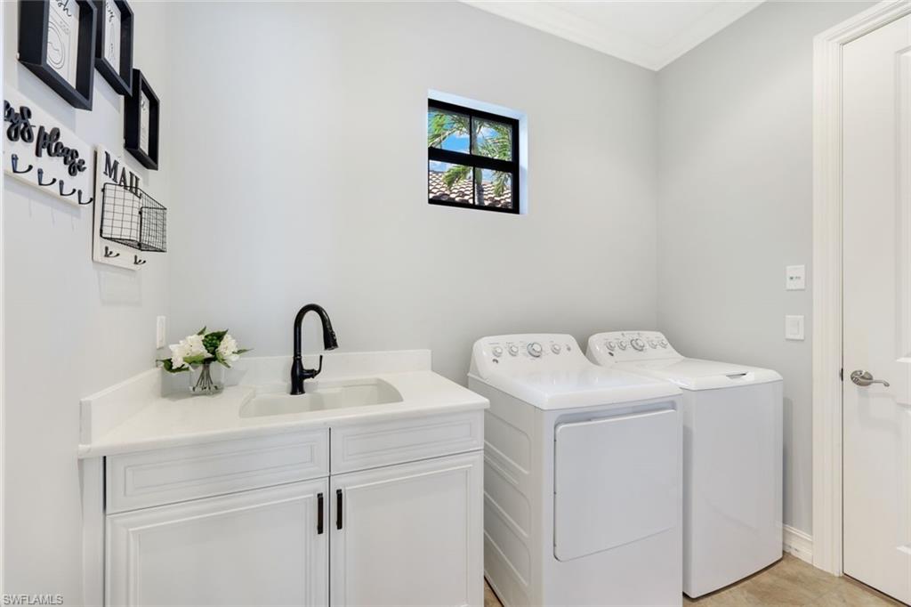 6592 Roma Way Naples, FL 34113 - Photo 23 of 41 Washroom featuring white cabinets, quartz counters, washer and dryer, crown molding, and sink