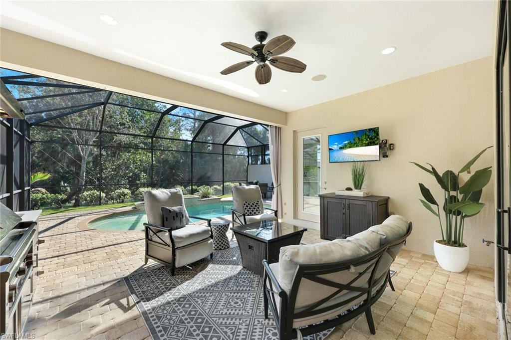 6592 Roma Way Naples, FL 34113 - Photo 24 of 41 Covered patio featuring outdoor kitchen with Lynx Grill/Hood, stainless storage drawers and cabinets, beverage cooler, stainless sink, recessed lighting, ceiling fan, fire pit and lounge area