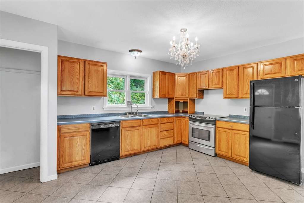 52 Warren Wright Road Belchertown, MA 01007 - Photo 14 of 41 a kitchen with stainless steel appliances granite countertop a sink window and refrigerator