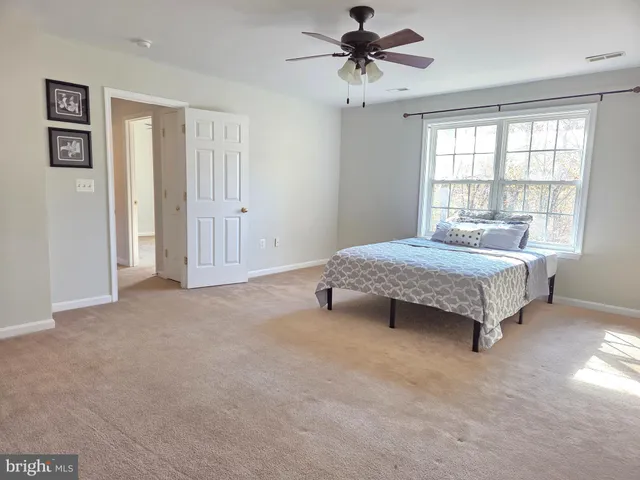 a spacious bedroom with a bed and a window