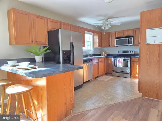 a kitchen with stainless steel appliances granite countertop a refrigerator a stove top oven a sink and dishwasher
