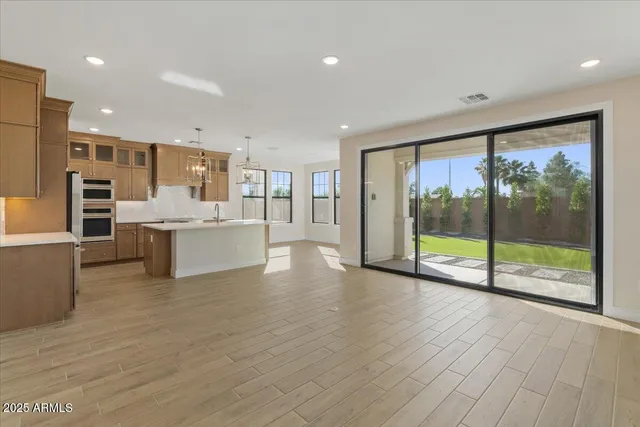 a large kitchen with granite countertop a large counter top stainless steel appliances and cabinets