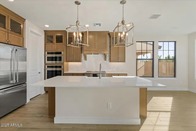 a kitchen with cabinets stainless steel appliances and wooden floor