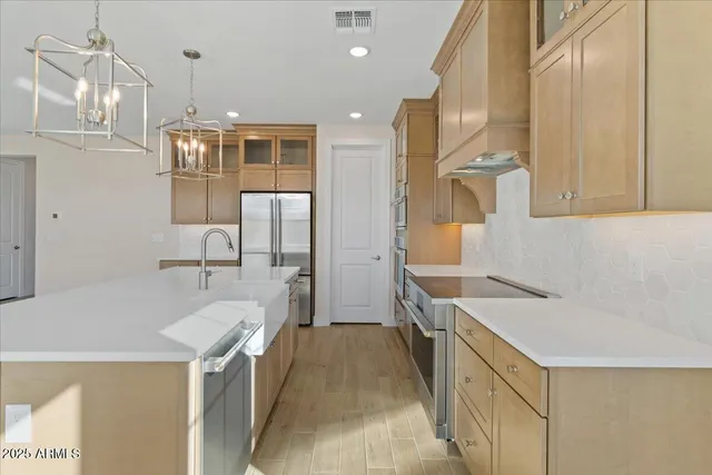 a view of a kitchen with kitchen island stainless steel appliances refrigerator sink and stove