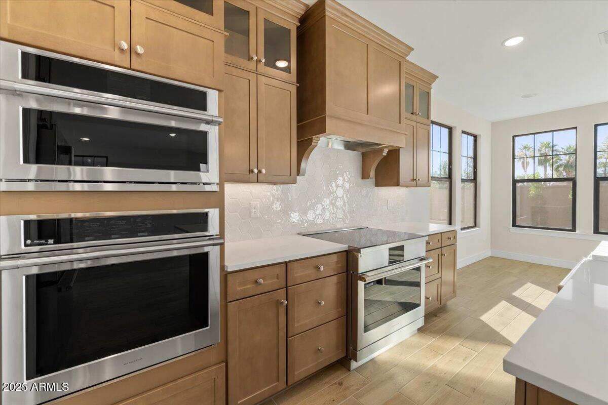 2431 West Los Arboles Place Chandler, AZ 85224 - Photo 22 of 60 a kitchen with cabinets stainless steel appliances and wooden floor