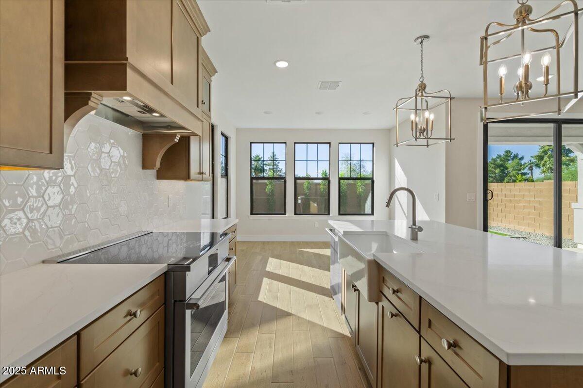 2431 West Los Arboles Place Chandler, AZ 85224 - Photo 23 of 60 a kitchen with granite countertop a sink stainless steel appliances a large window and cabinets