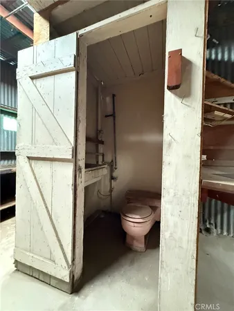 a view of an empty room with wooden floor and windows