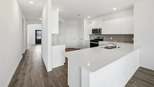 a kitchen with a sink a microwave and wooden floor