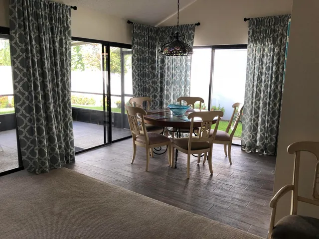 a dining room with furniture window and wooden floor