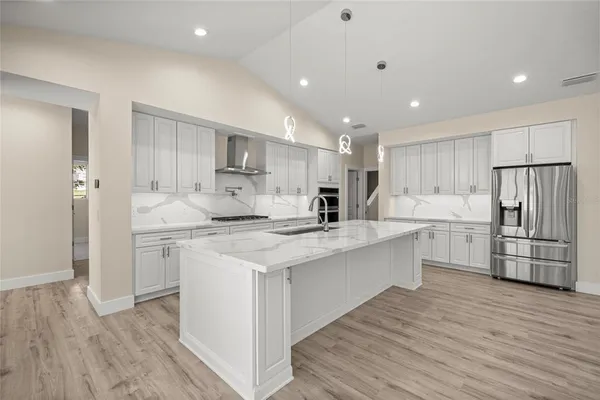 a kitchen with white cabinets and stainless steel appliances