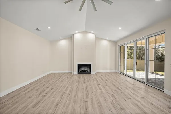 a view of a room with wooden floor fireplace and window