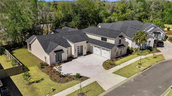 an aerial view of a house with a yard swimming pool and outdoor seating