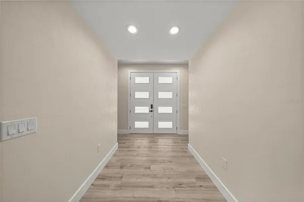 a view of a hallway with wooden floor and closet