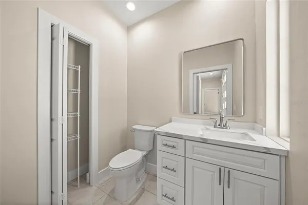 a bathroom with a toilet a sink a vanity and mirror