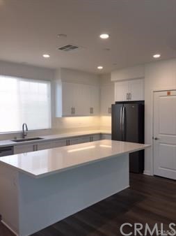 108 Terrapin Irvine, CA 92618 - Photo 4 of 14 a large kitchen with stainless steel appliances a large counter top a stove and a refrigerator