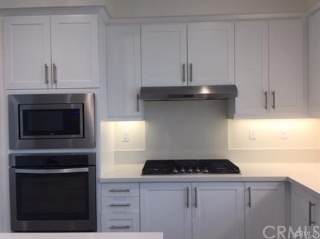 108 Terrapin Irvine, CA 92618 - Photo 5 of 14 a kitchen with granite countertop white cabinets and stainless steel appliances