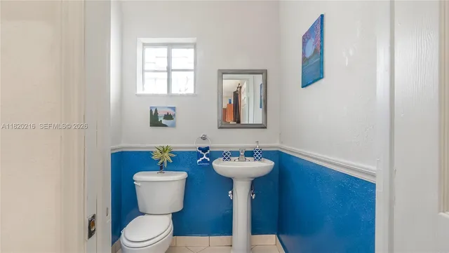 a bathroom with a toilet sink and mirror