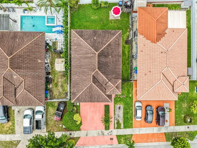 an aerial view of residential houses with outdoor space and parking