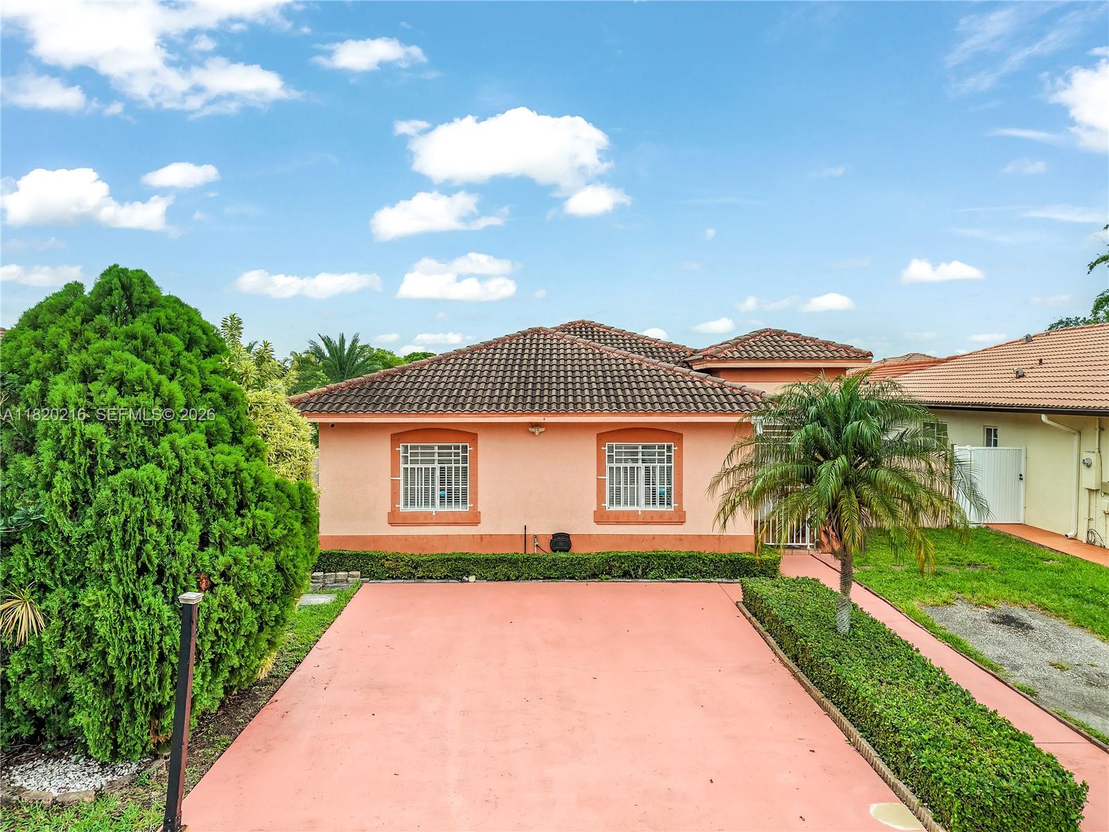 19730 Northwest 78th Avenue Hialeah, FL 33015 - Photo 29 of 30 a front view of a house with a yard and potted plants