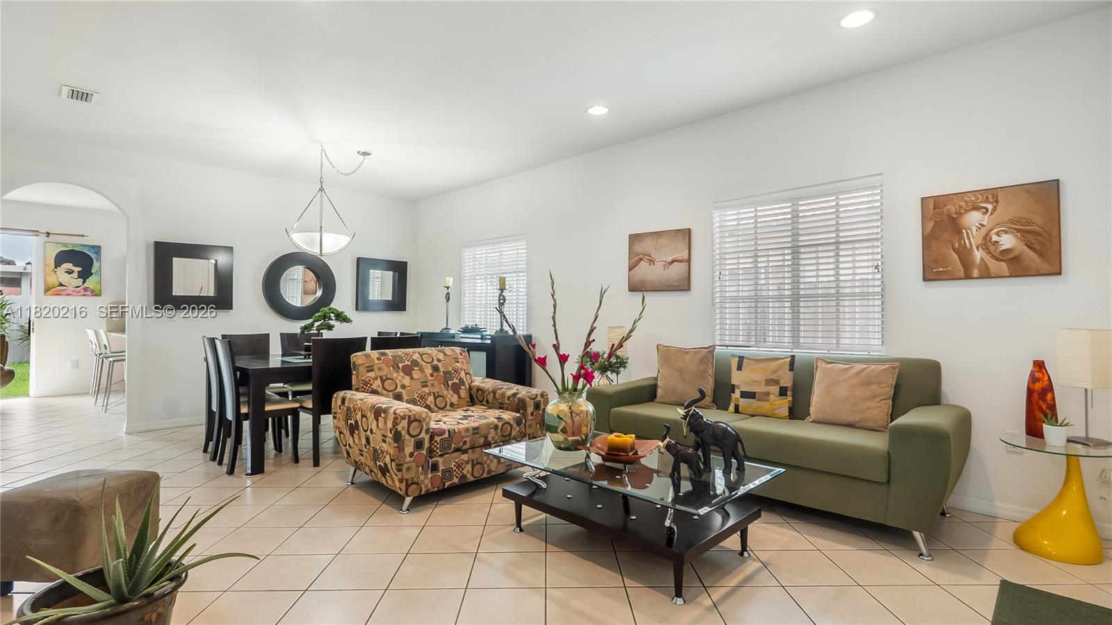 19730 Northwest 78th Avenue Hialeah, FL 33015 - Photo 3 of 30 a living room with furniture a clock on wall and a window