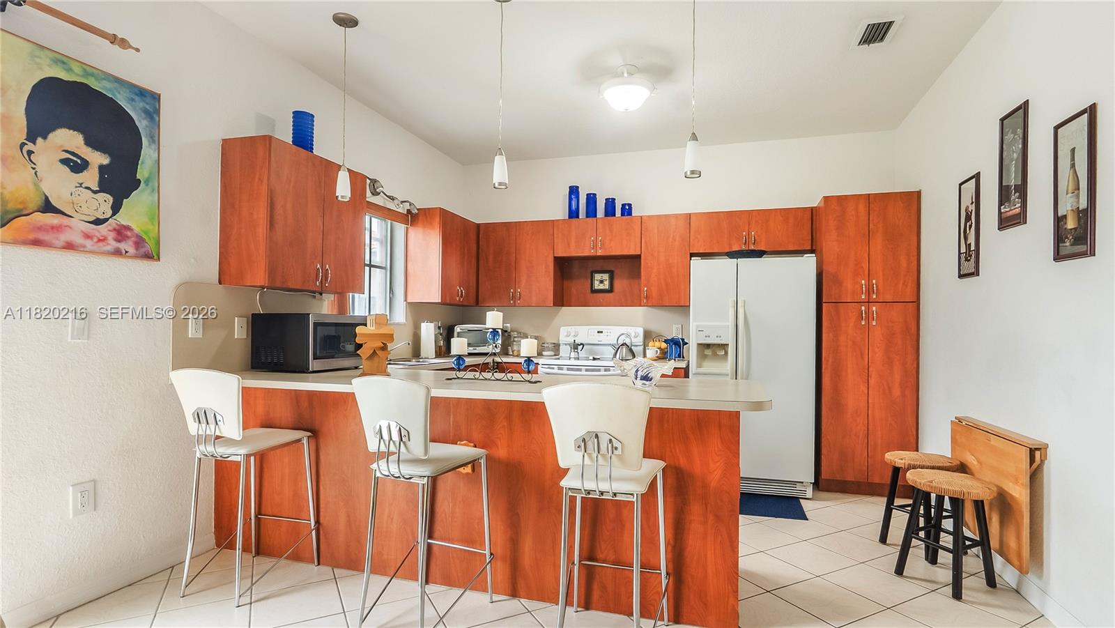 19730 Northwest 78th Avenue Hialeah, FL 33015 - Photo 8 of 30 a kitchen with stainless steel appliances kitchen island granite countertop a refrigerator and a dining table