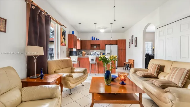 a kitchen with stainless steel appliances lots of white cabinets and chairs