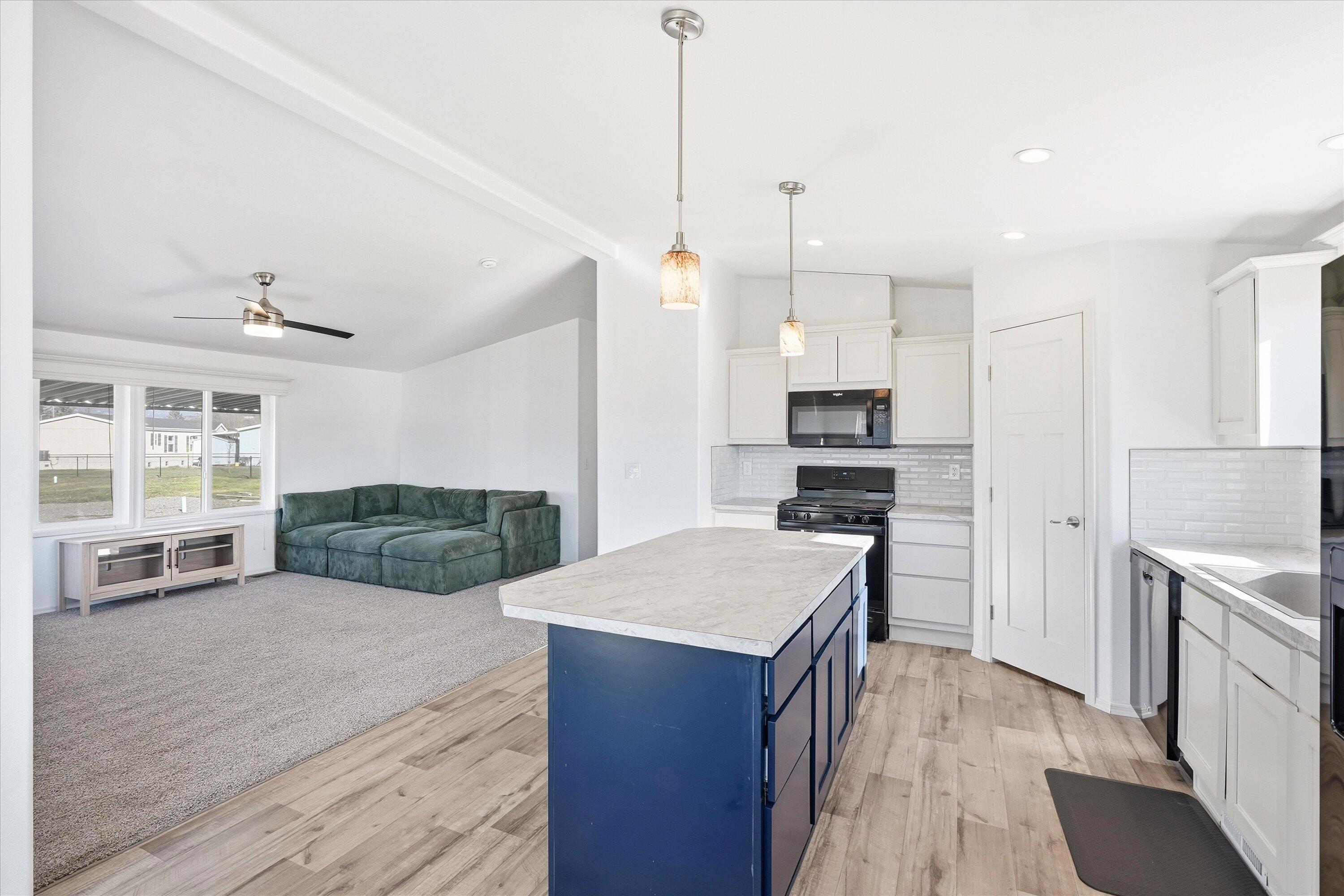300 Luman Road, Unit 197 Phoenix, OR 97535 - Photo 8 of 26 a kitchen with kitchen island a stove a sink and a refrigerator with wooden floor