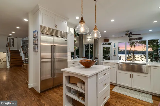 a view of a dining room and livingroom with furniture wooden floor a chandelier