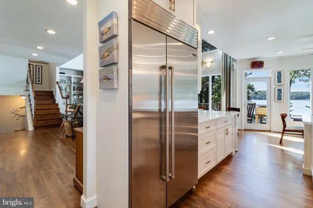 a bedroom with a bed and large window with wooden floor