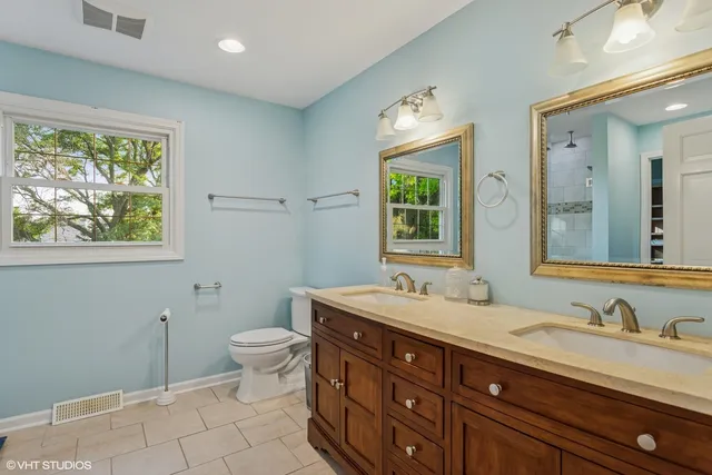 a bathroom with a granite countertop sink mirror and a toilet