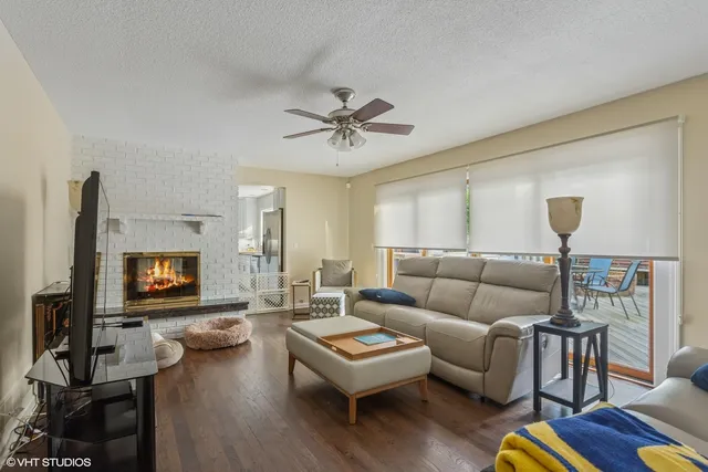 a living room with furniture a flat screen tv and a fireplace
