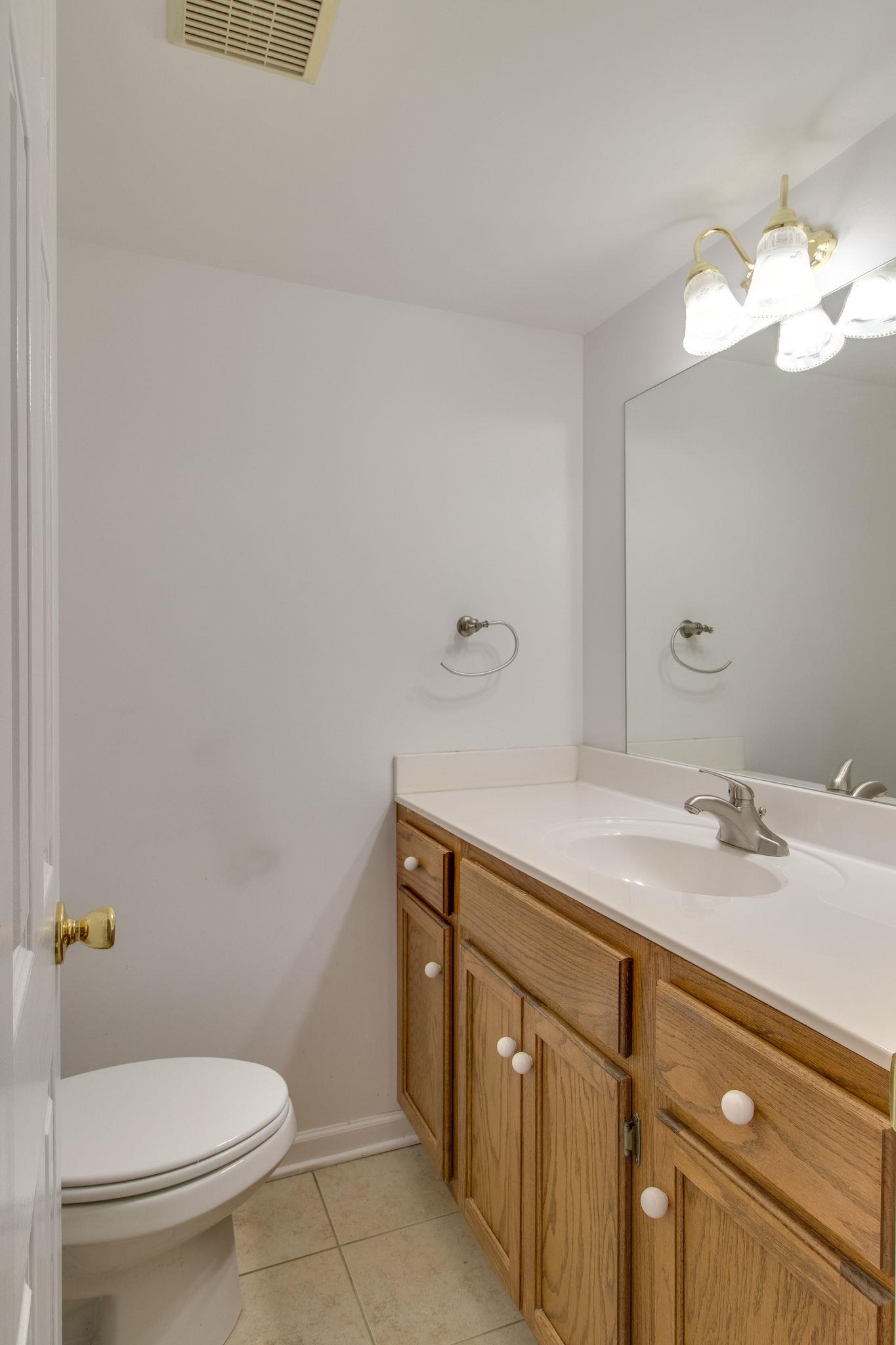 1253 General George Patton Road, Unit 1253 Nashville, TN 37221 - Photo 14 of 25 a bathroom with a sink a toilet and a mirror
