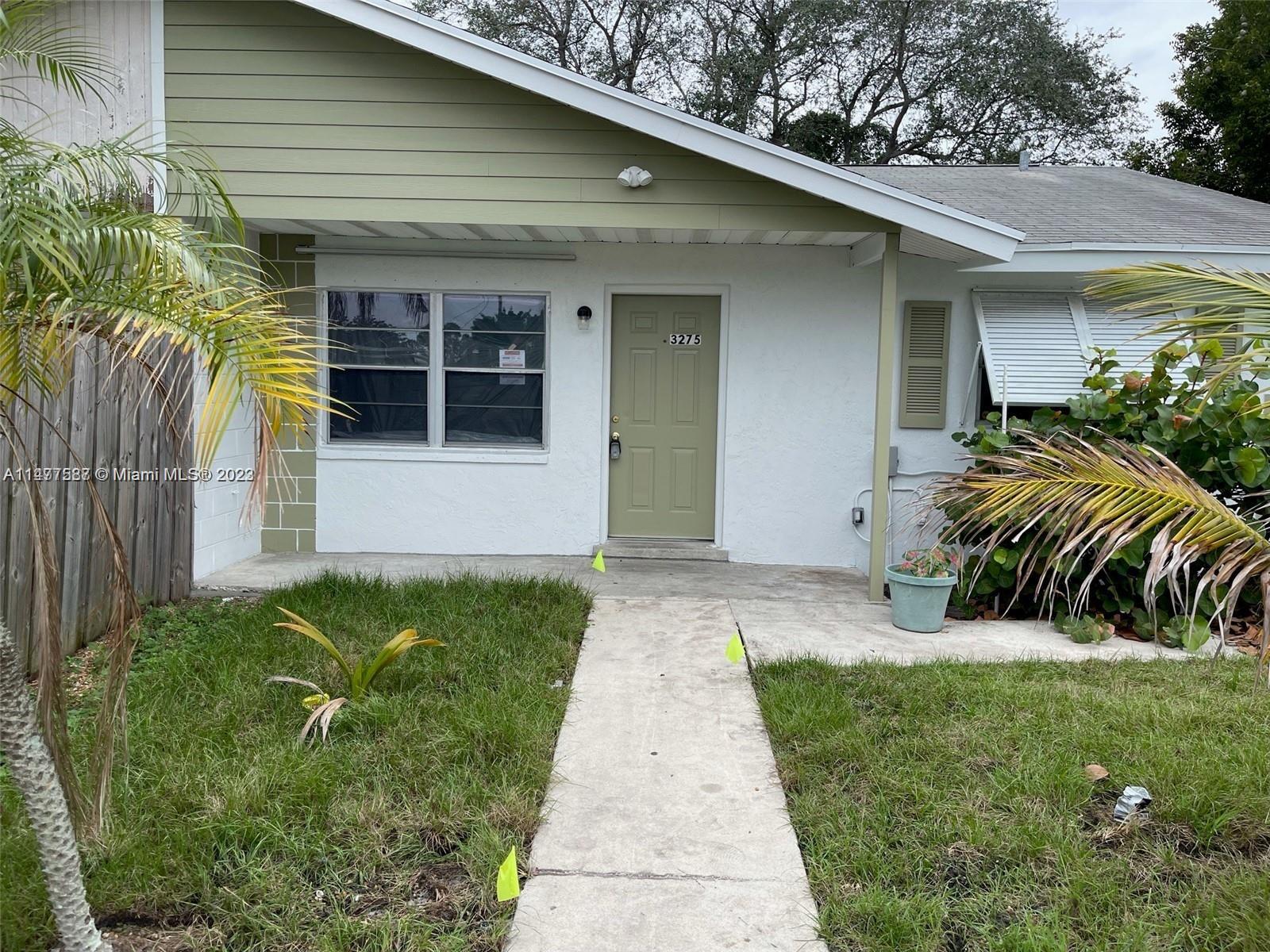 3275 Grove Road Boynton Beach, FL 33435 - Photo 1 of 3 a front view of a house with garden