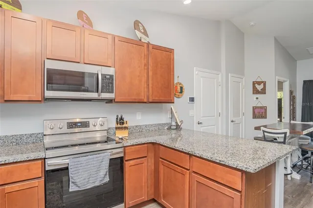 a kitchen with stainless steel appliances granite countertop a sink stove and microwave