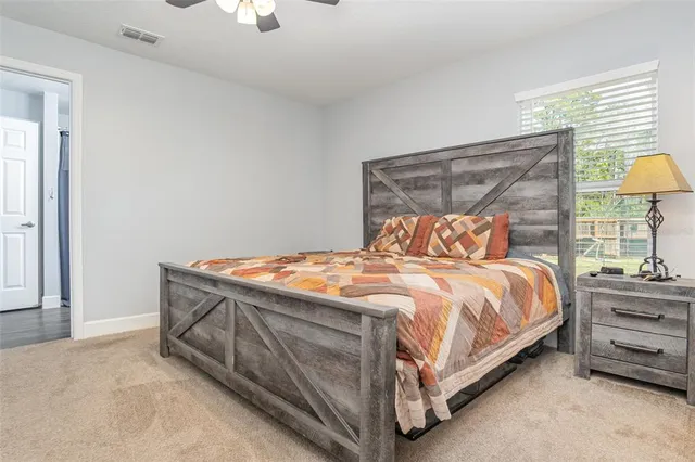 a bed sitting in a bedroom next to a lamp