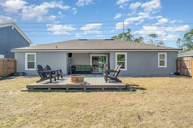 a view of the house with backyard and sitting area