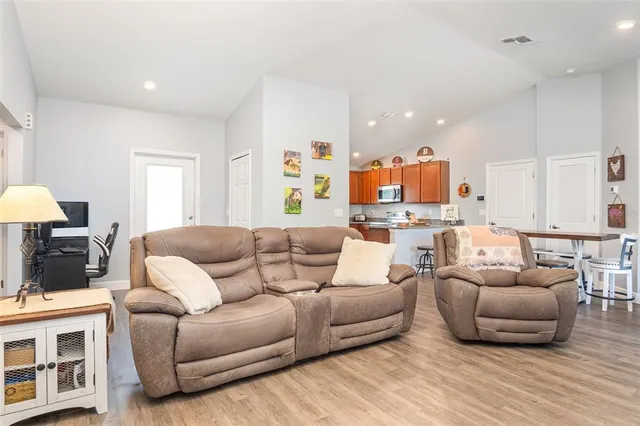 a living room with furniture and a wooden floor